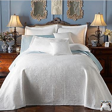 Fehér ágy ágyterítővel
